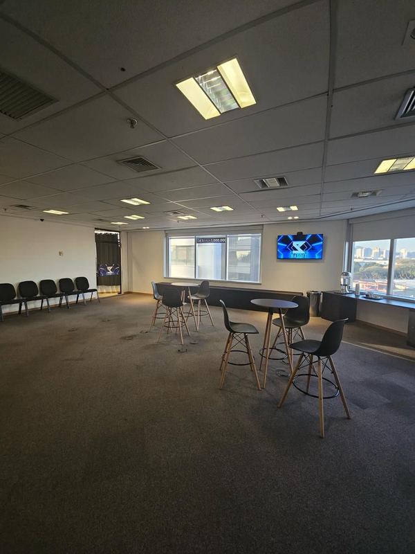 Espaço de networking com mesas altas e banquetas